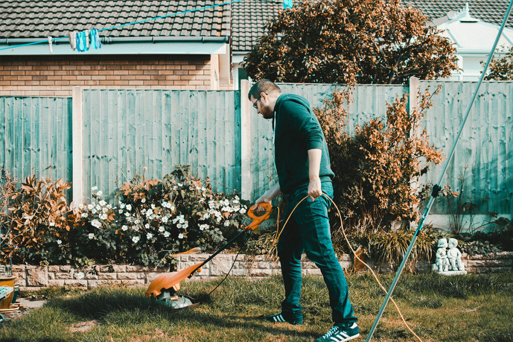 A man with an electric grass cutter